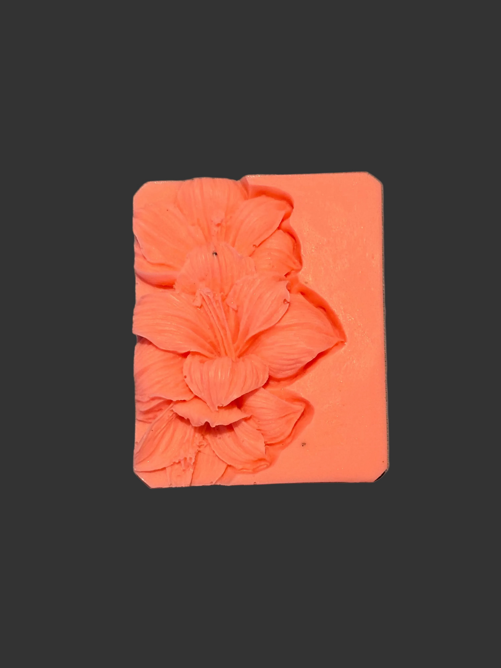 Orange silicone mold with floral design on a gray background